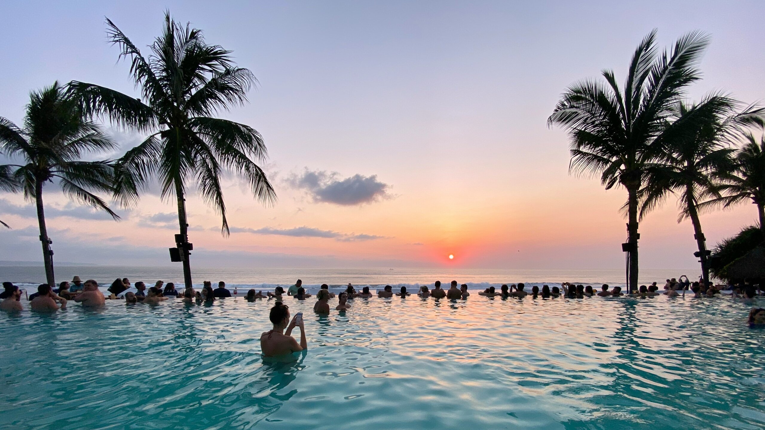 Sunset over water and palm trees