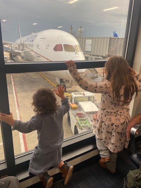 Two girls looking at United airplane